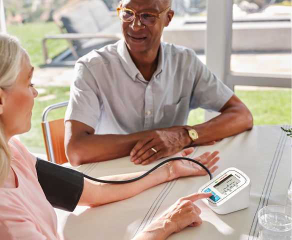 man and woman hanging out while the woman checks her blood pressure